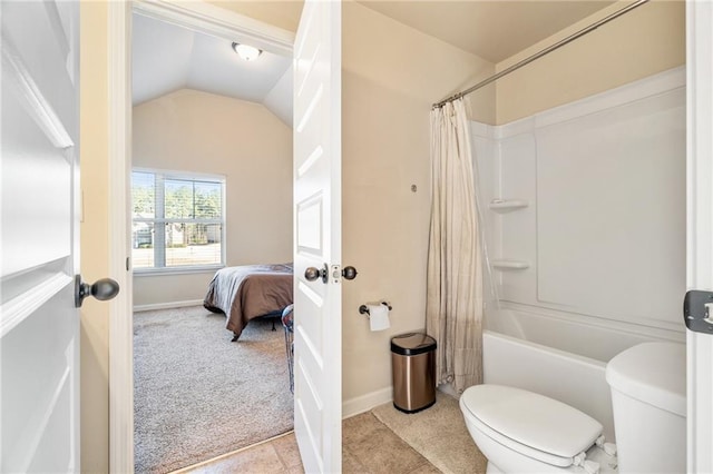 ensuite bathroom with connected bathroom, toilet, shower / tub combo, vaulted ceiling, and baseboards