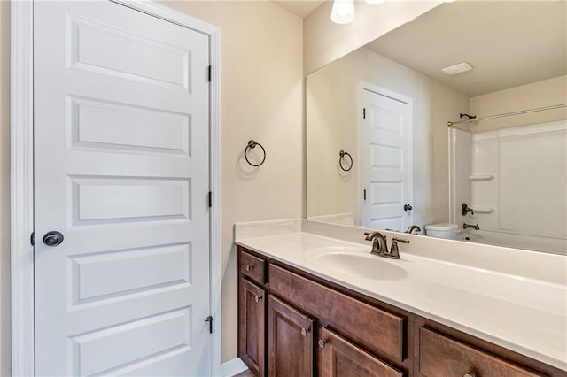 bathroom with washtub / shower combination, toilet, and vanity