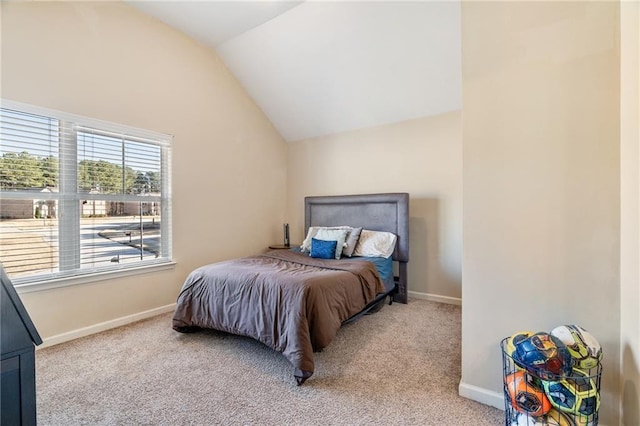 carpeted bedroom with baseboards and vaulted ceiling
