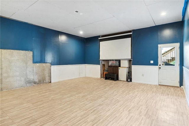 cinema featuring wood finished floors and a wainscoted wall