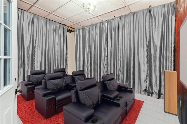 tiled home theater room featuring a paneled ceiling