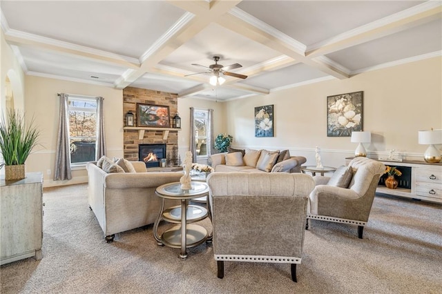 carpeted living area featuring coffered ceiling, a stone fireplace, and beam ceiling