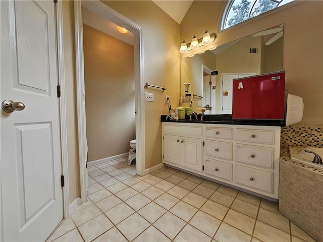 1988 Greensferry Gln, Lawrenceville, GA 30043 - bathroom with vanity, vaulted ceiling, toilet, tile patterned flooring, and tiled tub