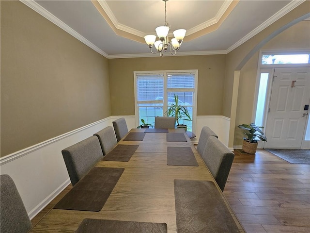 1988 Greensferry Gln, Lawrenceville, GA 30043 - dining area featuring a raised ceiling, arched walkways, a chandelier, hardwood / wood-style floors, and crown molding