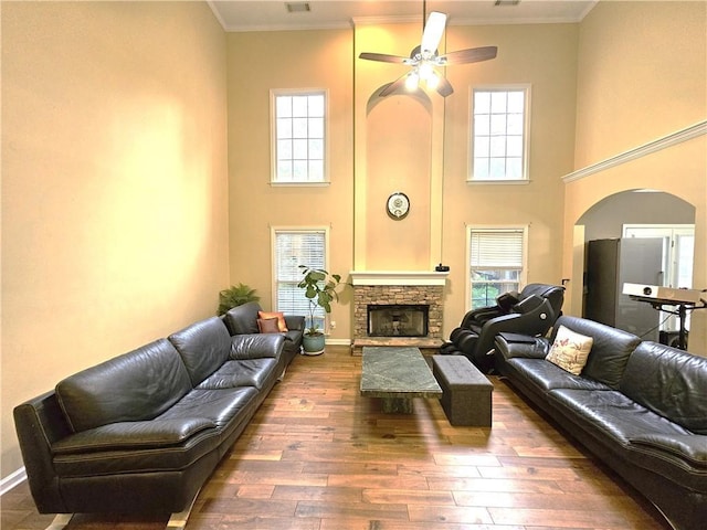 1988 Greensferry Gln, Lawrenceville, GA 30043 - living area featuring arched walkways, a high ceiling, a ceiling fan, a fireplace, and hardwood / wood-style flooring