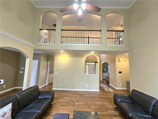 1988 Greensferry Gln, Lawrenceville, GA 30043 - living area with ceiling fan, baseboards, arched walkways, wood finished floors, and crown molding