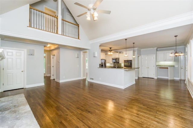 unfurnished living room featuring ceiling fan, a chandelier, dark wood-style floors, high vaulted ceiling, and ornamental molding