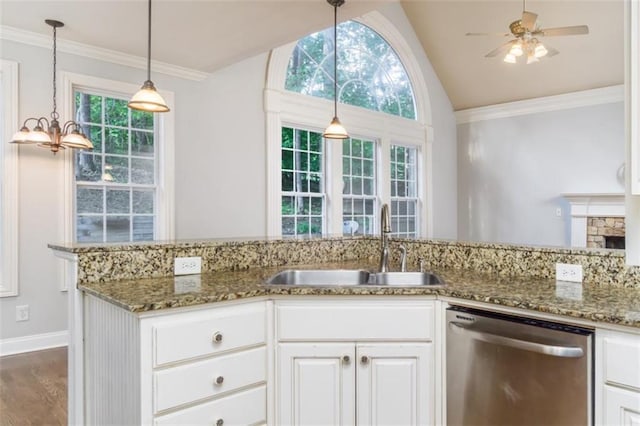 kitchen featuring dishwasher, a sink, vaulted ceiling, stone countertops, and white cabinets