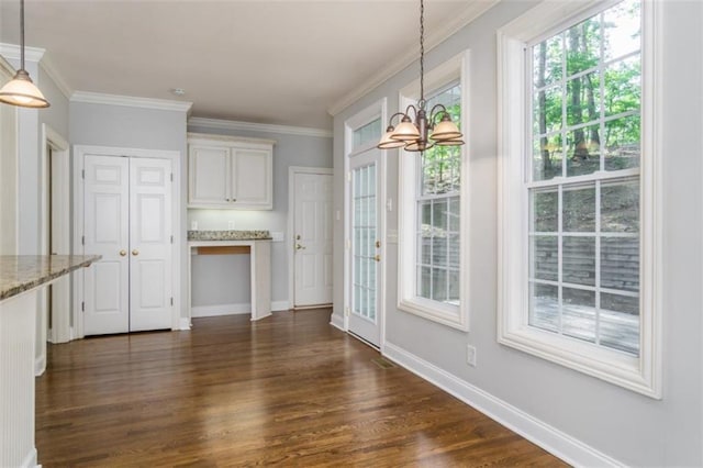 unfurnished dining area with a chandelier, dark wood-style flooring, baseboards, and crown molding