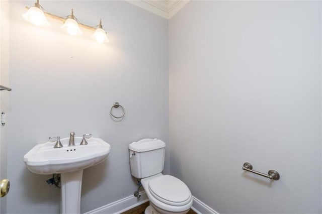 bathroom with ornamental molding, baseboards, and toilet