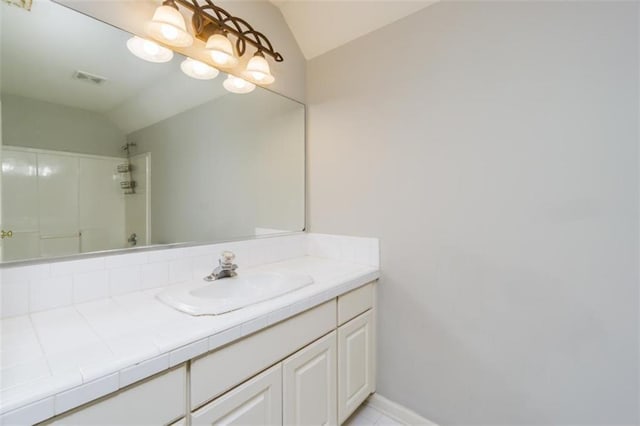bathroom with lofted ceiling, a shower, and vanity