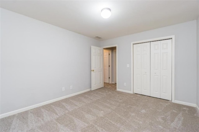 unfurnished bedroom with carpet floors, baseboards, and a closet