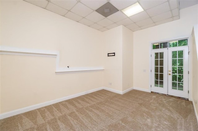 spare room with a paneled ceiling, french doors, carpet floors, and baseboards