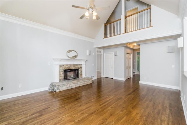 unfurnished living room featuring high vaulted ceiling, ceiling fan, a stone fireplace, wood finished floors, and baseboards