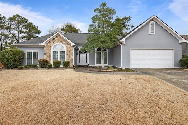 single story home featuring a garage, stone siding, concrete driveway, and stucco siding