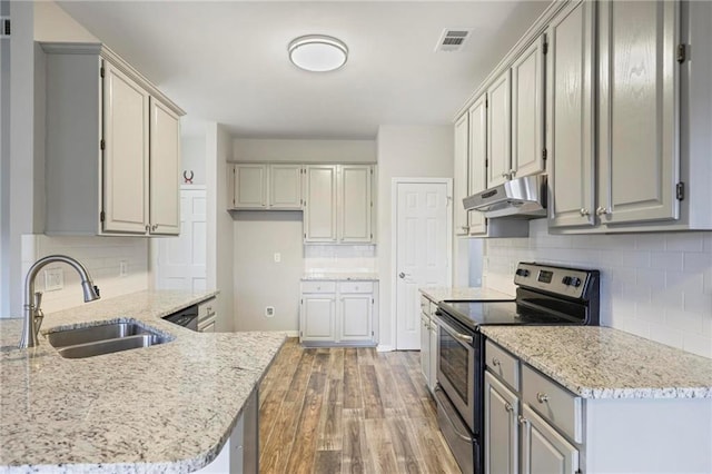 kitchen with under cabinet range hood, a sink, visible vents, light wood-type flooring, and stainless steel electric stove