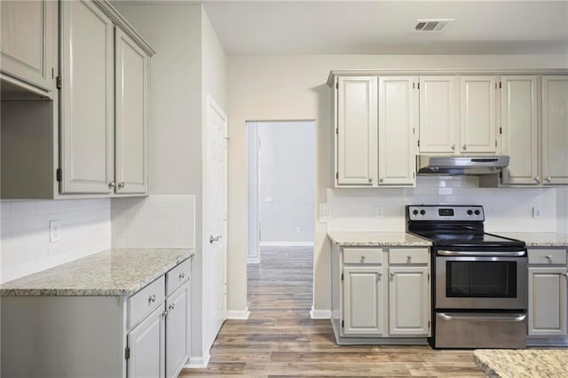 kitchen with under cabinet range hood, visible vents, gray cabinets, light wood finished floors, and stainless steel range with electric stovetop