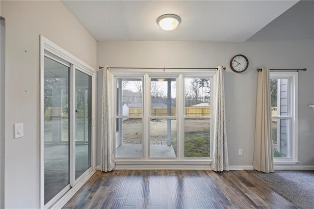 doorway with wood finished floors and baseboards