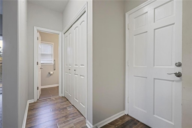 hallway with dark wood-style floors and baseboards