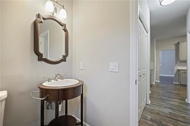 bathroom featuring toilet, baseboards, and wood finished floors