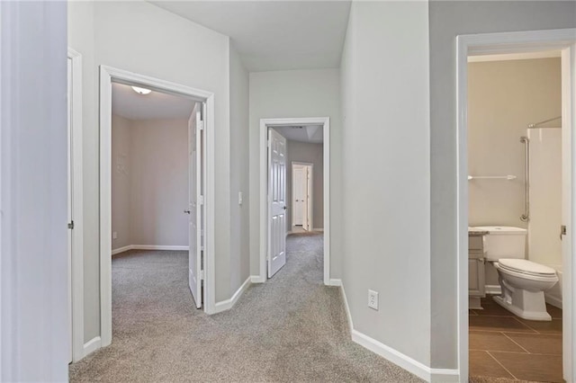 hall featuring carpet floors and baseboards