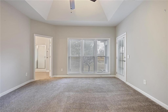 spare room with ceiling fan, carpet, baseboards, and a raised ceiling