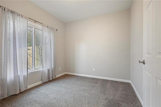 unfurnished room featuring carpet and baseboards