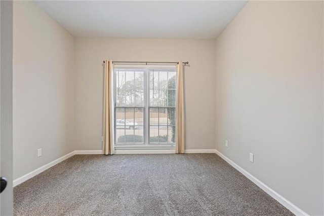 carpeted spare room featuring baseboards