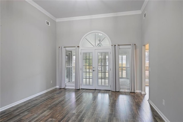 spare room featuring baseboards, ornamental molding, dark wood-type flooring, and french doors