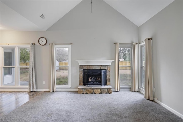 unfurnished living room featuring carpet floors, visible vents, baseboards, and a stone fireplace