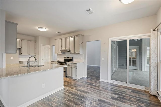 kitchen with dark wood-style flooring, stainless steel electric stove, a sink, a peninsula, and under cabinet range hood