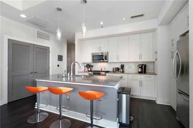 kitchen with backsplash, dark wood-type flooring, sink, appliances with stainless steel finishes, and white cabinetry