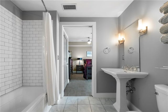 bathroom featuring toilet, shower / tub combo with curtain, and ceiling fan