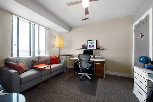 office featuring ceiling fan, dark carpet, and a wealth of natural light