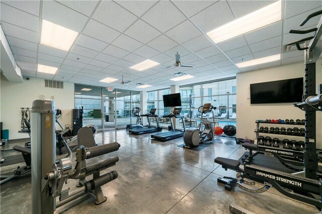 gym with ceiling fan and a drop ceiling