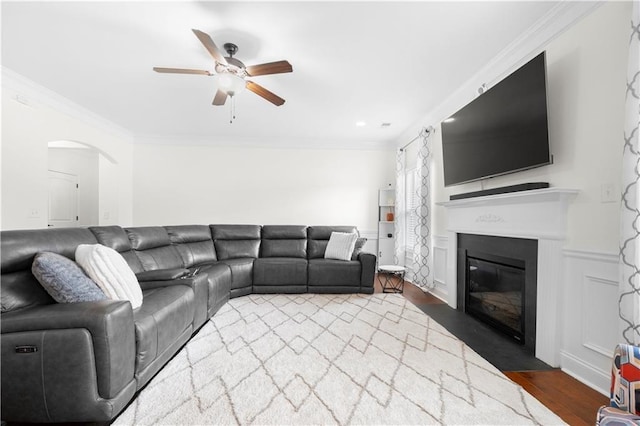 living room with ornamental molding, dark hardwood / wood-style floors, and ceiling fan