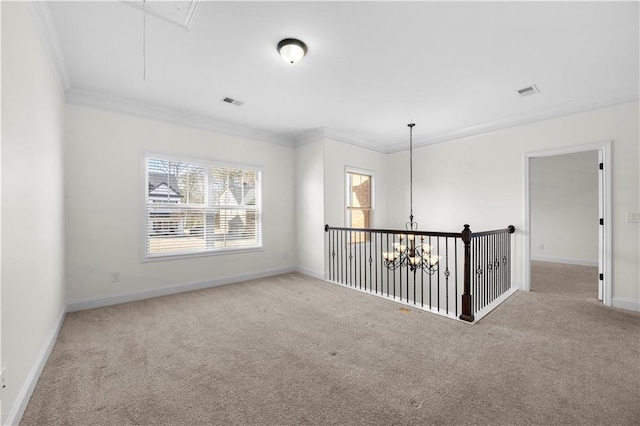 spare room with ornamental molding, carpet flooring, and a notable chandelier