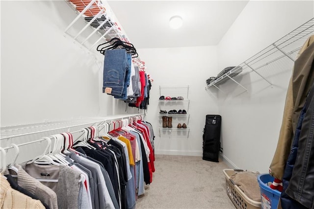 walk in closet featuring light colored carpet