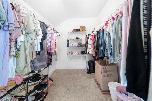 walk in closet featuring vaulted ceiling and light colored carpet