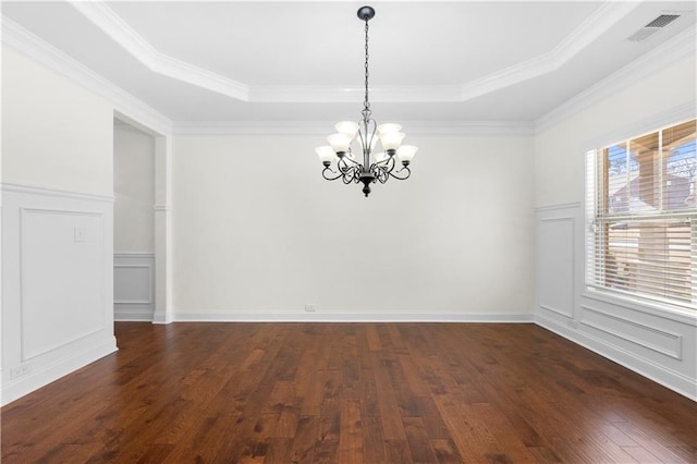 spare room featuring an inviting chandelier, dark hardwood / wood-style flooring, and a raised ceiling