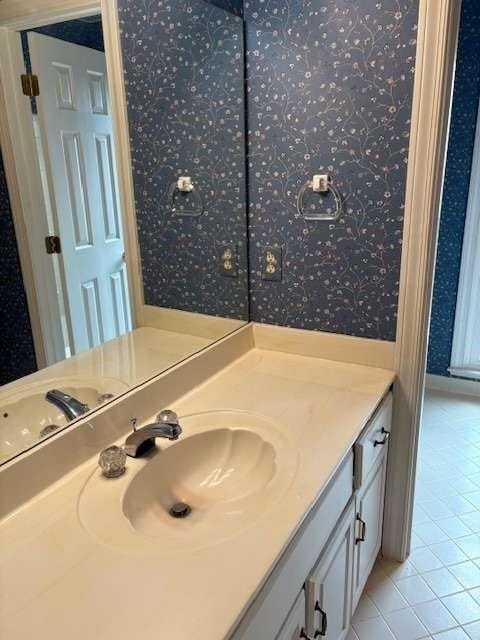 bathroom featuring vanity, tile patterned flooring, and wallpapered walls