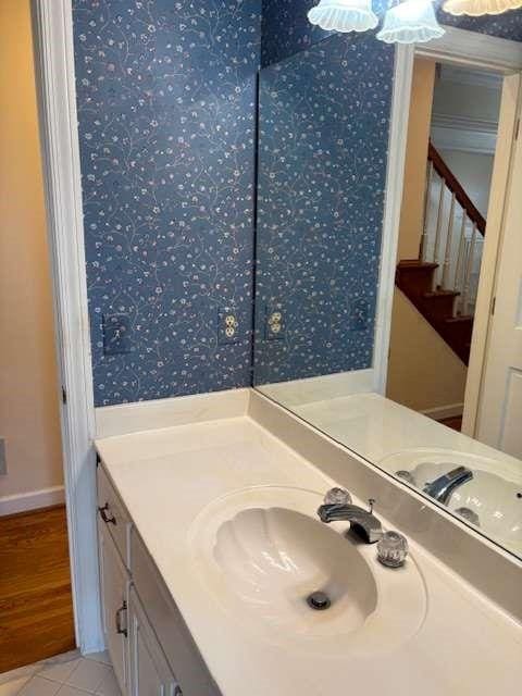 bathroom featuring tile patterned floors, vanity, and wallpapered walls