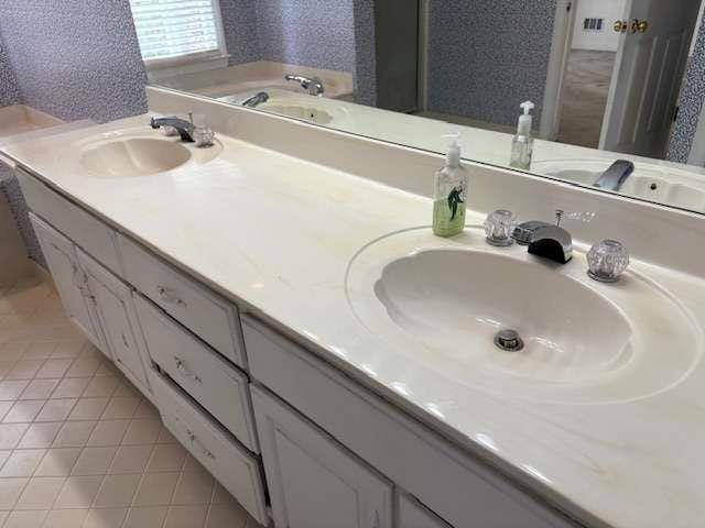 bathroom with a sink, double vanity, and tile patterned flooring