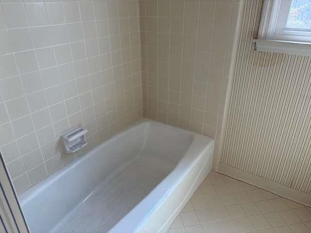 full bath featuring tile patterned flooring and baseboards