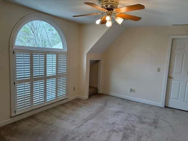 interior space with baseboards, carpet floors, and ceiling fan