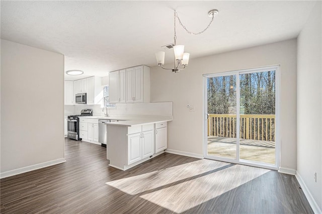 kitchen featuring an inviting chandelier, hanging light fixtures, appliances with stainless steel finishes, plenty of natural light, and white cabinetry