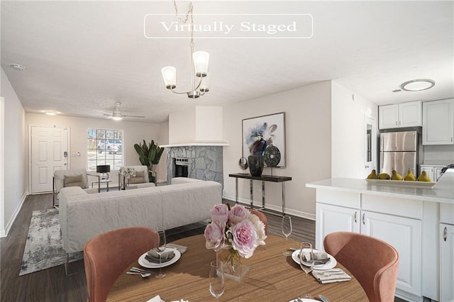 dining room with dark wood-type flooring and ceiling fan with notable chandelier