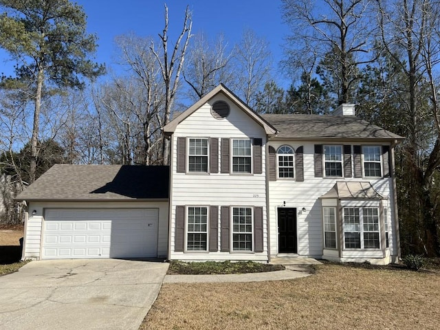 view of front of property featuring a garage and a front yard