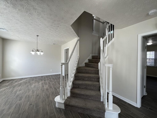 stairs featuring a chandelier and a textured ceiling