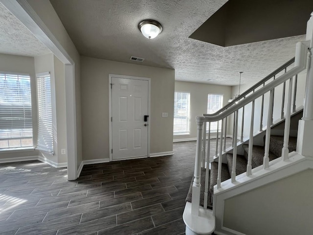 foyer entrance featuring a textured ceiling